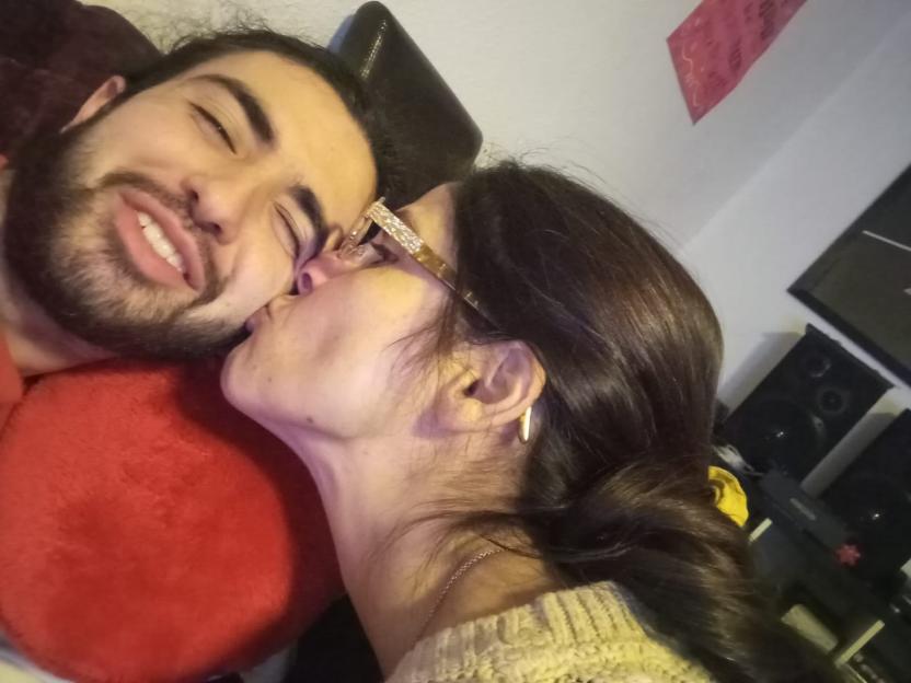 A woman kissing a man on the cheek.