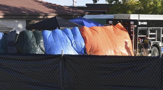 Crime scene secured with tarps and fence.