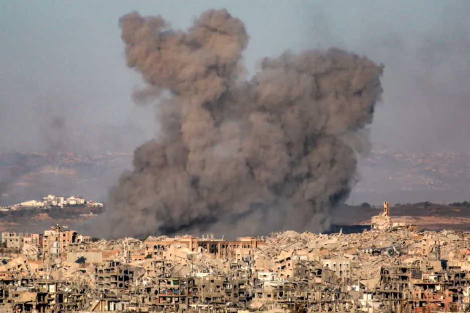 Large plume of smoke over war-torn city.