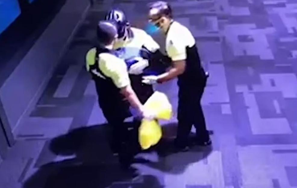 CCTV footage of authorities in Qatar holding a baby found in a toilet bin.