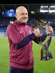 Lee Carsley, England's Under-21 head coach, holding the UEFA European Under-21 Championship trophy.