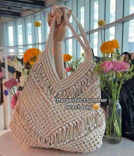 Beige crocheted beach bag with white beads.