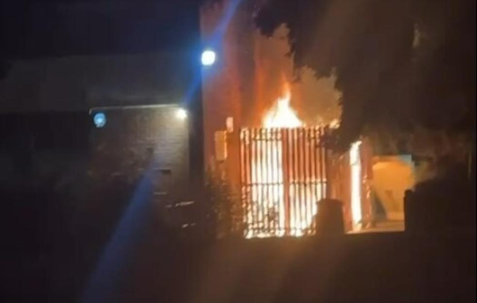 Housing block engulfed in flames at night.