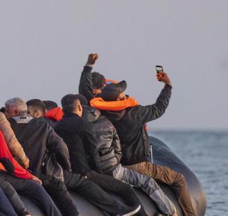Migrants in a small boat taking a selfie while crossing the English Channel.