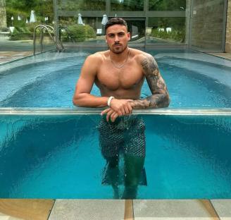 Man with tattoos in a pool.