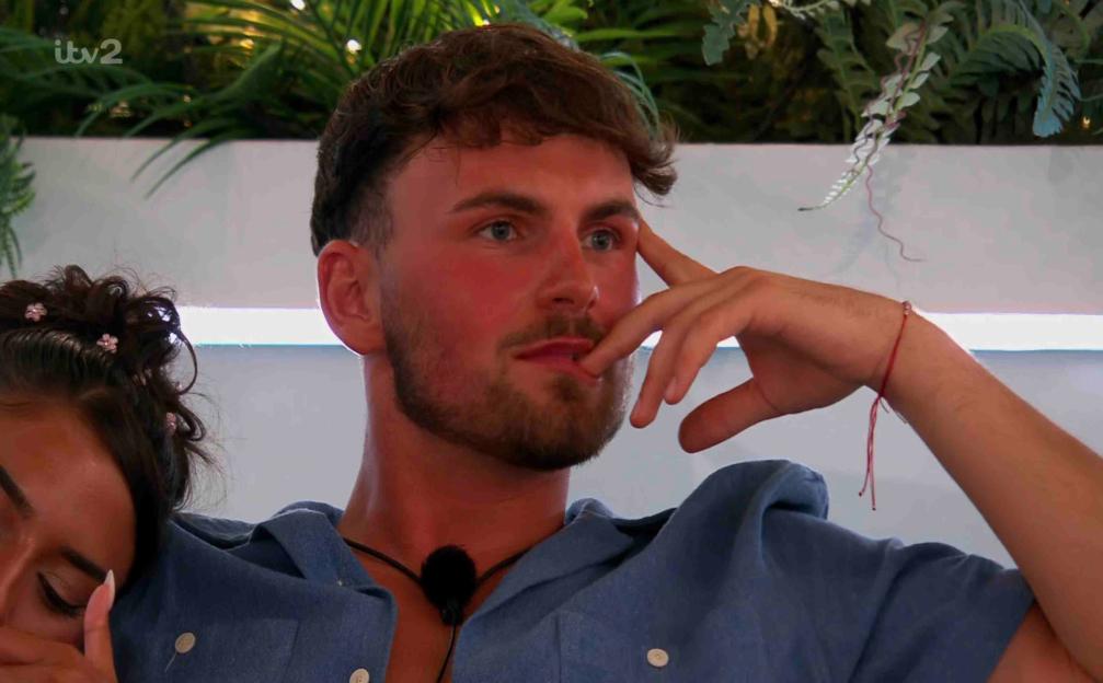 Screenshot from Love Island showing a man in a blue shirt.