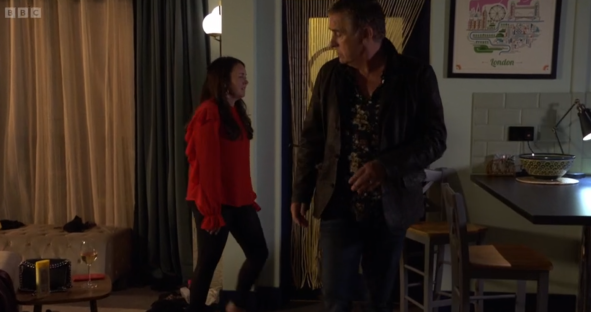 Screenshot of a man and woman talking in a room.