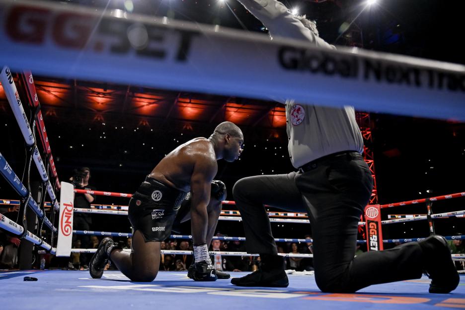 Daniel Dubois of Great Britain kneeling in a boxing ring after being knocked down.