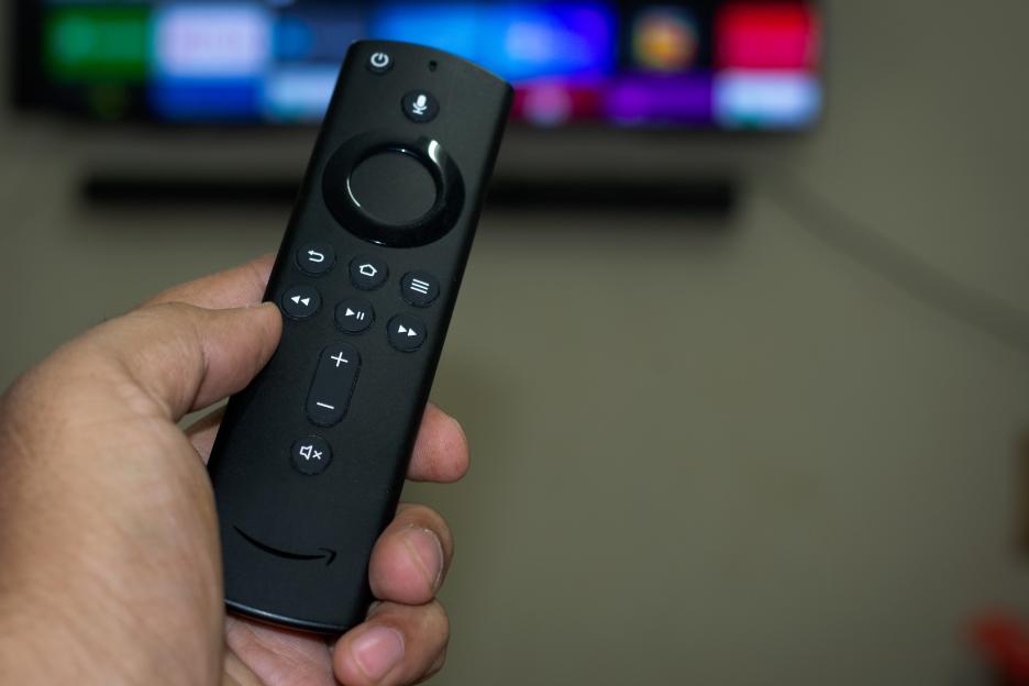 Hand holding Amazon Fire Stick TV remote.
