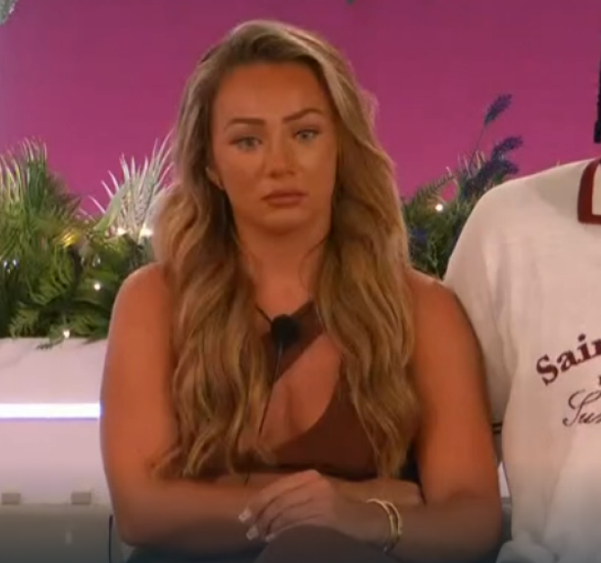 Screenshot of a woman with long blonde hair looking upset.
