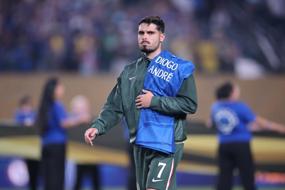 Chelsea FC player Pedro Neto holding a jersey with the names Diogo and André, in tribute to the deceased football players.