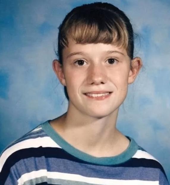 Portrait of a young girl with bangs wearing a striped shirt.