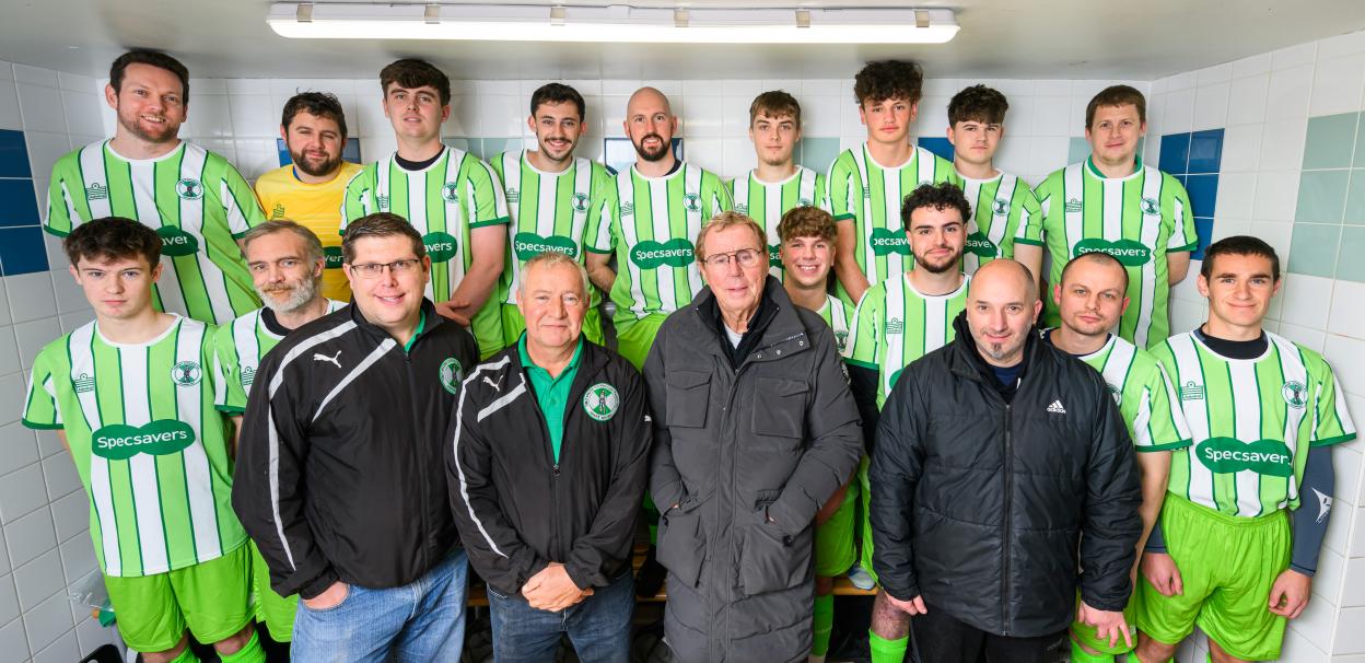 Tunley Athletic FC football team with managers and Harry Redknapp in a changing room.