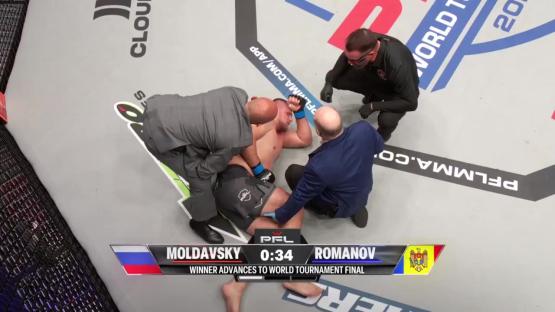 A fighter lying on the mat surrounded by medical personnel.
