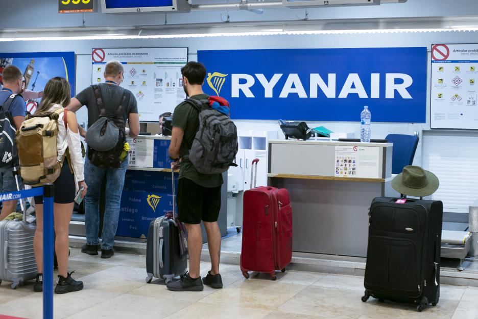 Passengers at a Ryanair check-in counter.