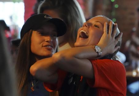 Two women celebrating England's victory at a pub.
