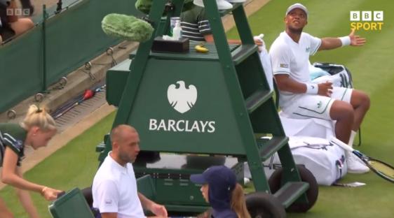 Tennis player sitting on a Barclays-branded chair umpire stand.