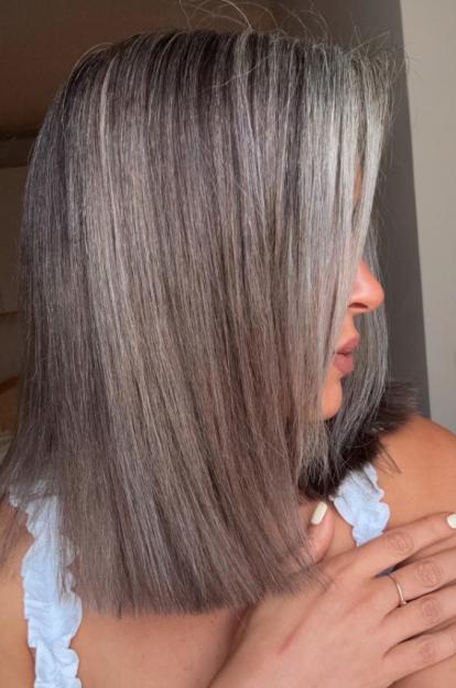 Woman with gray and brown shoulder-length hair.