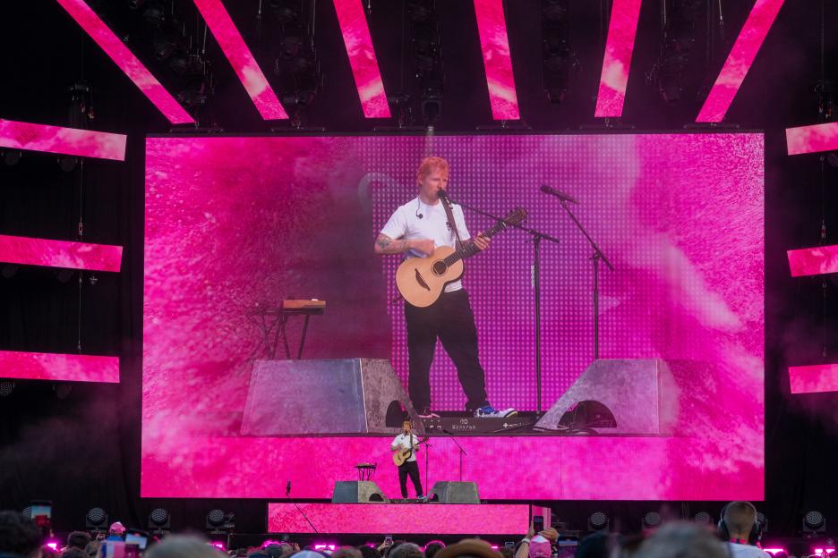 Ed Sheeran performing at a concert.