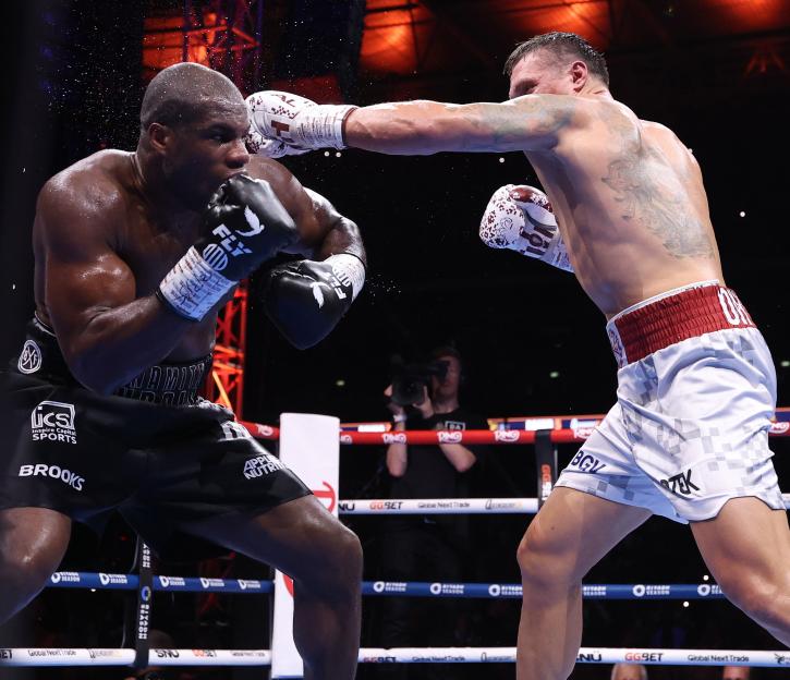 Oleksandr Usyk punches Daniel Dubois in a boxing match.