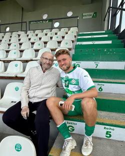 Phil Collins with his son Matthew at a soccer stadium.