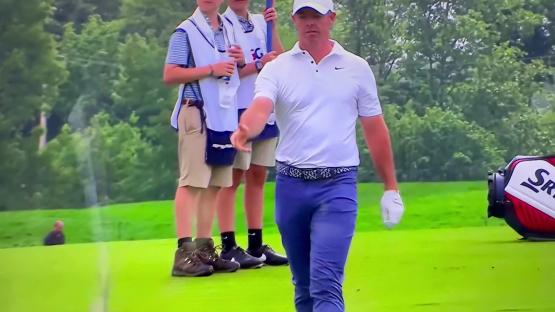 Rory McIlroy walking on a golf course.