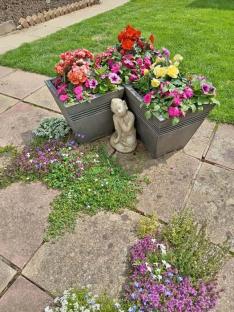 Patio with flower planters and a small statue.