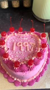 Pink heart-shaped cake in a box.
