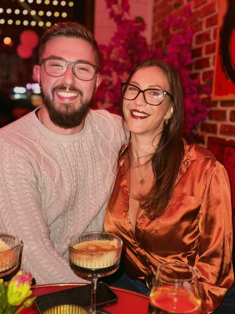 A woman and man smiling together at a bar.