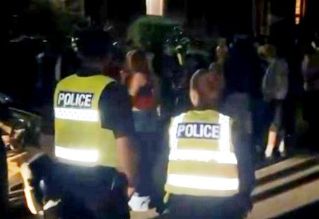 Police officers at a noisy student party.