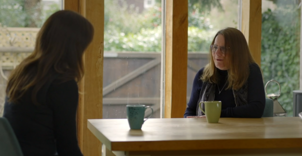 Two women sitting at a table, talking.