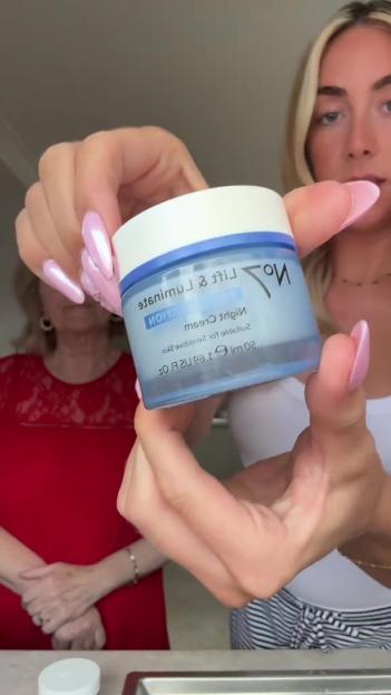 Woman holding a jar of No7 Lift & Luminate Night Cream.