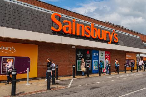 People socially distancing while queuing outside a Sainsbury's supermarket.