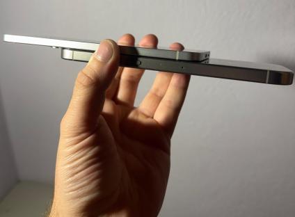 Hand holding two smartphones, one on top of the other.