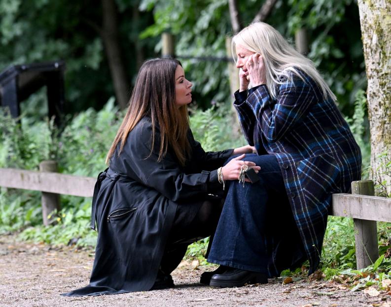 Two women filming an emotional scene in a park.
