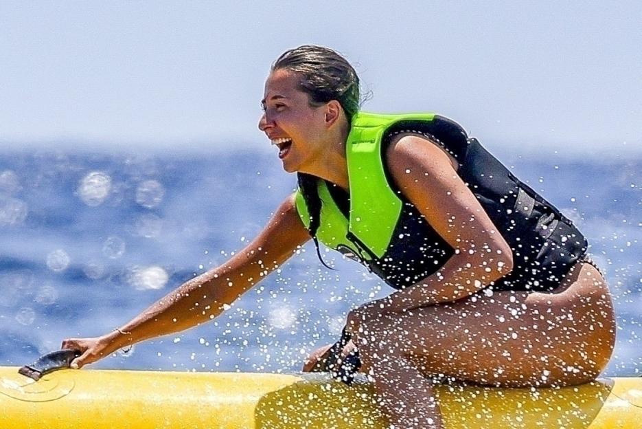 Woman laughing while riding an inflatable boat.
