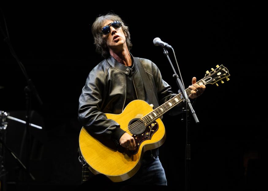 Richard Ashcroft performing with a guitar.