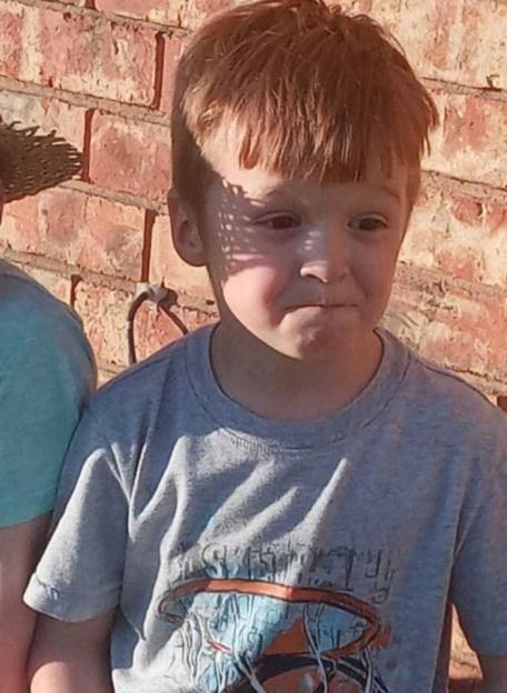 Young boy with red hair wearing a grey t-shirt.