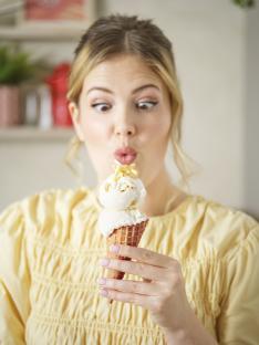 Woman looking surprised at a potato ice cream cone.