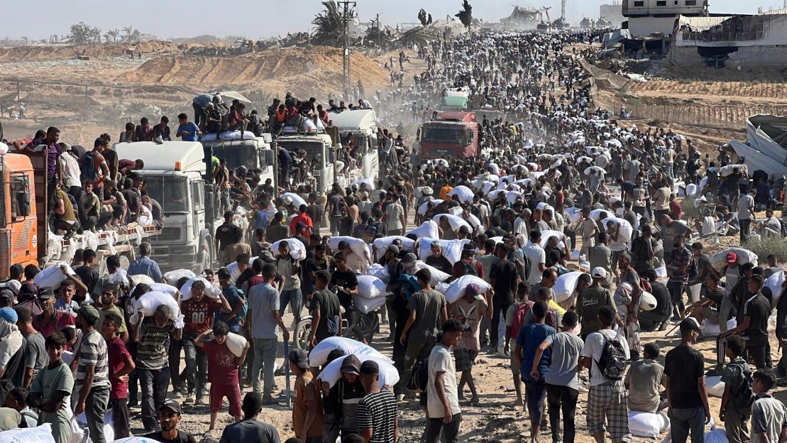 Hundreds of Palestinians seizing trucks carrying flour in Khan Younis, southern Gaza Strip.