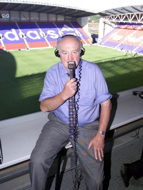 Ray French, sportscaster, speaking into a microphone in a stadium commentary booth.