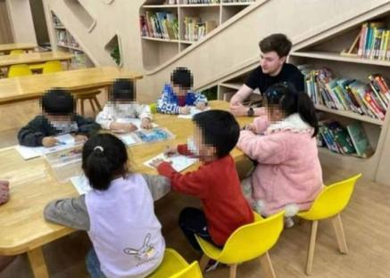 A young teacher with a group of children in a classroom.