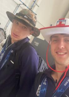 Two young men wearing hats and lanyards.