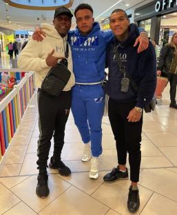 Three men posing for a photo together in a shopping mall.