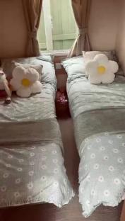 Two twin beds with floral bedding and daisy pillows.