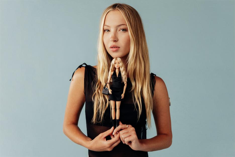 Woman holding a Barbie doll with type 1 diabetes accessories.