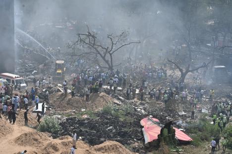 Plane crash site with emergency responders and debris.