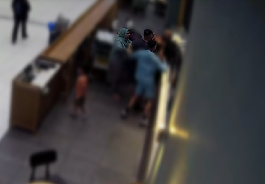 Blurry photo of a group of people standing near a counter.