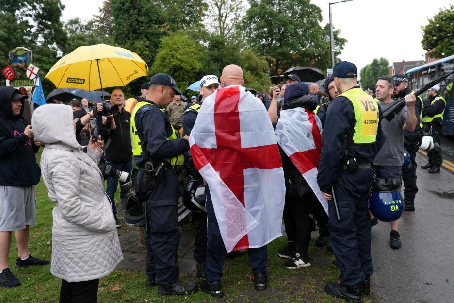 Protestors with St. George's flags speak to police.