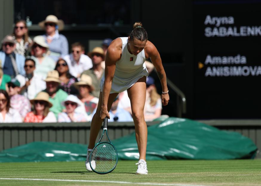 Aryna Sabalenka bending over after a point in her Wimbledon semi-final match against Amanda Anisimova.